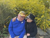 Photo of a couple smiling with park in the background